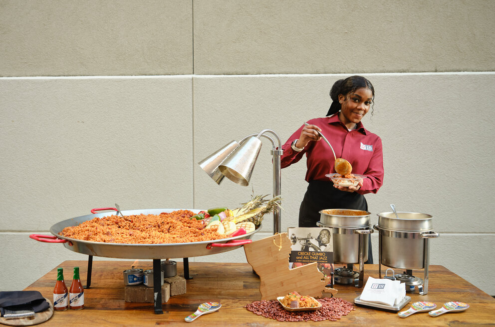 A woman serving red beans and rice