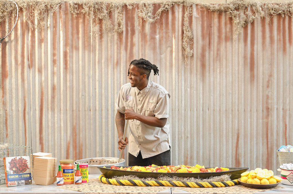 A man stirring a crawfish boil pot